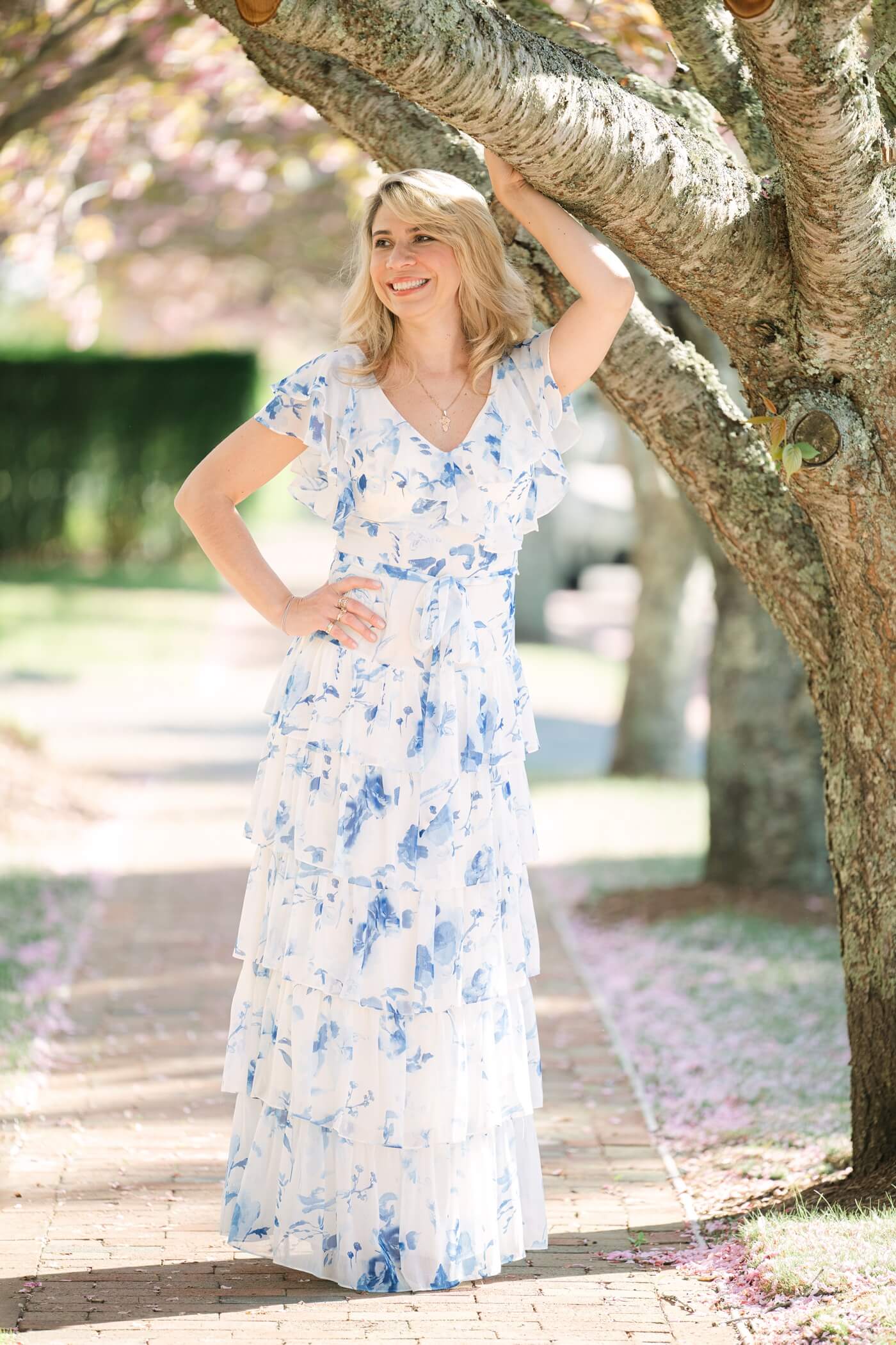 Woman holding pink flowers during spring portrait session in Nantucket Nantucket portrait photographer captures springtime beauty